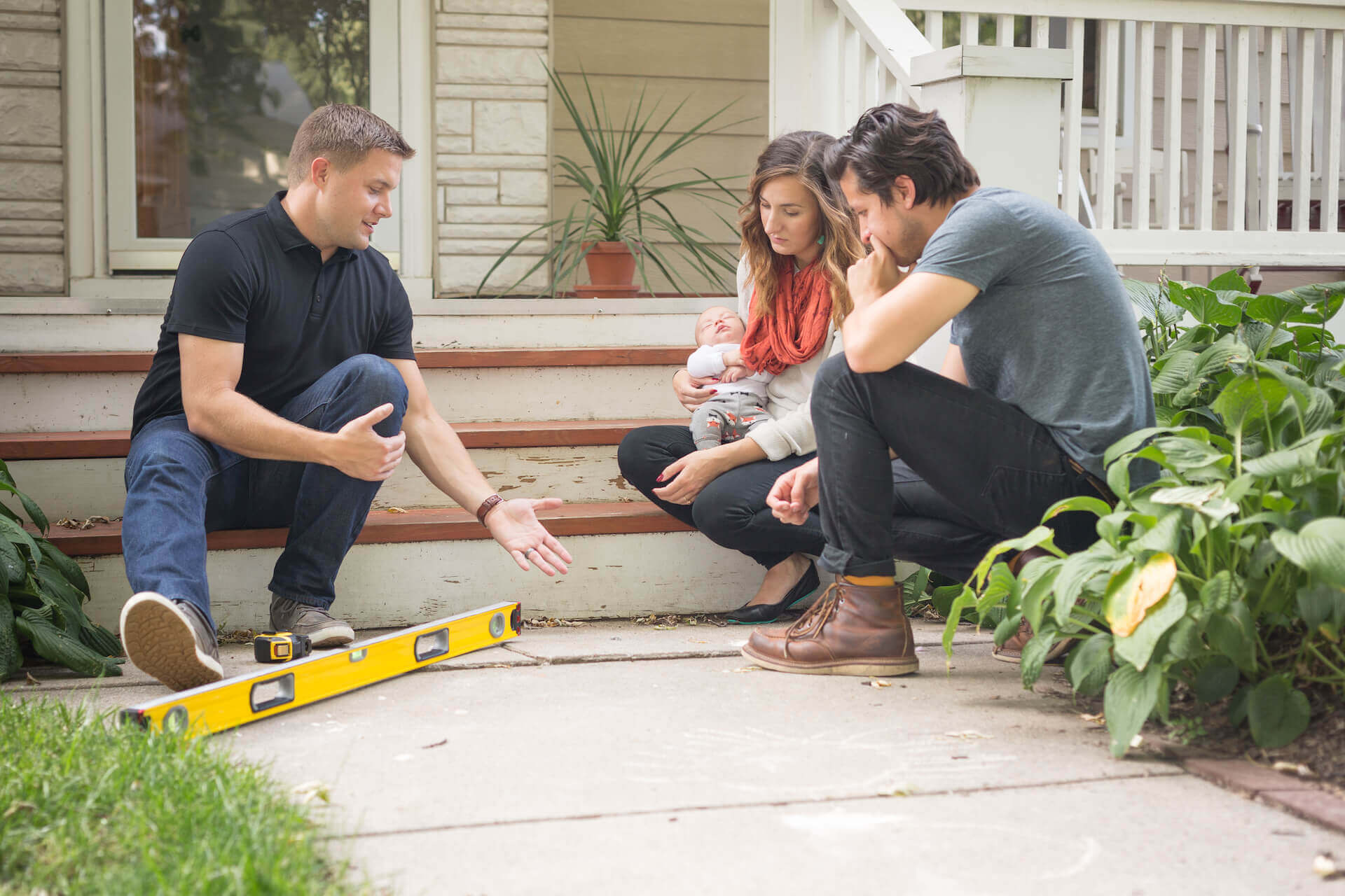 Young couple discussing their homes sidewalk